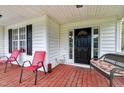 Inviting front porch with seating, featuring bright red chairs and a charming wicker bench with floral cushions at 2709 White Rail Dr, Fuquay Varina, NC 27526