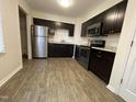 Modern kitchen features stainless steel appliances, stylish dark cabinets, and luxury vinyl plank flooring at 2809 Haven Rd, Raleigh, NC 27610