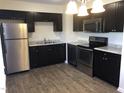 Modern kitchen features stainless steel appliances, stylish dark cabinets, and granite countertops at 2809 Haven Rd, Raleigh, NC 27610