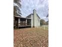 Backyard view showcases a covered porch, white fencing, and a lush, private setting at 306 Smoketree Way, Louisburg, NC 27549