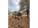 Spacious backyard featuring a covered porch, mature trees, and a unique firepit area with log seating at 306 Smoketree Way, Louisburg, NC 27549