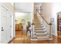 Inviting foyer featuring hardwood floors, a staircase, and entryways to adjacent rooms at 316 Pebble Beach Dr, Mebane, NC 27302