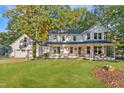 Charming two-story home featuring a covered front porch and attached garage in a lush, green yard at 347 Cook Rd, Elon, NC 27244