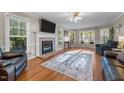 Cozy living room featuring a fireplace, hardwood floors, large windows, and comfortable seating at 347 Cook Rd, Elon, NC 27244