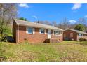 Quaint single-story brick house exhibiting a neat yard and mature trees at 369 Albany St, Burlington, NC 27215