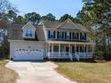 Charming two-story home with a large front porch, attached garage, and well-maintained lawn at 382 Tomahawk Dr, Clayton, NC 27520
