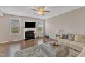 Bright living room boasts a cozy fireplace, hardwood floors, and large windows for ample natural light at 3925 Massey Pointe Ct, Raleigh, NC 27616