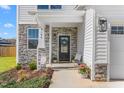 Inviting front porch with stone accents, a decorative wreath, and a cozy bench at 4104 Ralph Holt Ct, Snow Camp, NC 27349