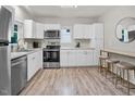 Bright kitchen features stainless appliances, white cabinets and breakfast bar area at 4408 Poplar Dr, Raleigh, NC 27610