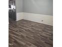 Dining area boasts dark wood-style flooring and wainscoting, adjacent to a modern kitchen at 5016 Gailardia Dr, Zebulon, NC 27597