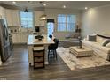 Spacious living room and kitchen featuring an island with seating, stainless steel appliances, and cozy decor at 5045 Kota St, Raleigh, NC 27610