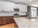 Bright kitchen with white subway tile backsplash, stainless steel appliances, granite countertops, and modern fixtures at 5347 Cypress Ln, Raleigh, NC 27609