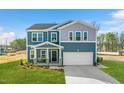 Charming two-story home featuring a covered front porch, well-manicured lawn, and a two-car garage at 6529 Winter Spring Dr, Wake Forest, NC 27587