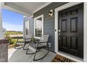 Inviting front porch with comfortable seating, offering a relaxing outdoor space next to the front door at 6529 Winter Spring Dr, Wake Forest, NC 27587