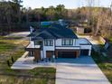 Aerial view of modern home showcasing roof, large driveway, and ample outdoor space at 73 Clyde Pearce Rd, Zebulon, NC 27597