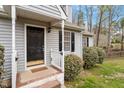 Charming front porch with light gray siding, black shutters and a welcoming entrance at 815 Riverbark Ln, Durham, NC 27703