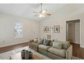 Bright and airy living room featuring a high ceiling, a fan, a modern sofa, and stylish decor at 815 Riverbark Ln, Durham, NC 27703