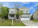 Charming two-story home featuring a covered front porch, stone accents, and an attached two-car garage at 1 Serenity Ct, Durham, NC 27704