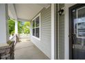 Cozy front porch detail showcasing a covered area with railing, perfect for enjoying the outdoors at 1 Serenity Ct, Durham, NC 27704
