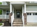 Welcoming front porch with stone pillars, white railing, and steps leading to the home's entrance at 1 Serenity Ct, Durham, NC 27704