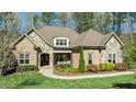 Charming brick and stone home with meticulously landscaped front yard and covered front porch at 1009 High Trail Ct, Wake Forest, NC 27587