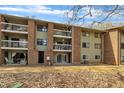 Exterior view of the rear of the apartment building with balconies and a green common area with fall leaves at 1283 Schaub Dr # B, Raleigh, NC 27606