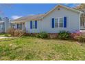 A quaint single-story home with light siding and blue shutters stands on a neatly landscaped lot at 133 Grassy Rio Ln, Garner, NC 27529