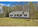Lovely one-story house featuring white siding, black shutters and a cute porch overlooking the front yard at 188 Hunter Ln, Zebulon, NC 27597