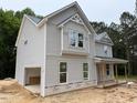Light gray two-story home featuring a side entry garage and covered porch at 1945 Cranes Creek Rd, Cameron, NC 28326