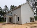 Side view of a light gray two-story home featuring a garage and covered porch at 1945 Cranes Creek Rd, Cameron, NC 28326