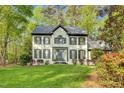 Charming two-story home with black trim, surrounded by lush greenery, and professionally landscaped at 201 Wortham Dr, Raleigh, NC 27614