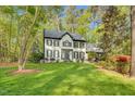 A manicured front lawn and mature trees frame a beautiful home with classic architectural details at 201 Wortham Dr, Raleigh, NC 27614