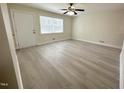 Inviting living room with a door to the outside, a ceiling fan and updated flooring at 313 Main St, Knightdale, NC 27545