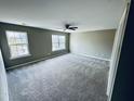 Spacious bedroom with neutral walls, plush carpet, and bright windows with outdoor views at 3316 Perkins Ridge Rd, Raleigh, NC 27610
