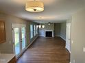 Bright living room with fireplace, modern lighting, and patio doors to the green yard at 3316 Perkins Ridge Rd, Raleigh, NC 27610