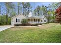 Attractive home exterior with a covered porch, attached garage, and a large yard, surrounded by trees at 340 Castleberry Rd, Clayton, NC 27527