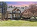 Charming brick home with blue shutters, lush lawn, and mature trees showcasing curb appeal at 3601 Tartancroft Pl, Fuquay Varina, NC 27526