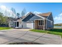 Spacious home with a two-car garage, stone accents, and a large driveway with a lake in the background at 390 Lake Magnolia Way, Smithfield, NC 27577