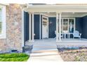 Inviting front porch with chairs and side table, stone accents, and well-maintained landscaping at 390 Lake Magnolia Way, Smithfield, NC 27577