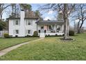 Charming two-story home featuring a brick chimney, a welcoming porch, and well-manicured landscaping at 4900 Skidmore St, Raleigh, NC 27609