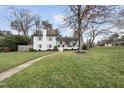 Charming two-story home featuring a brick chimney, a welcoming porch, and well-manicured landscaping at 4900 Skidmore St, Raleigh, NC 27609