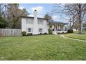 Charming two-story home featuring a brick chimney, a welcoming porch, and well-manicured landscaping at 4900 Skidmore St, Raleigh, NC 27609