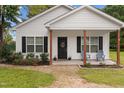 Charming front porch with black door, seating, and well-maintained landscaping and beautiful plants at 501 E Granville St, Dunn, NC 28334