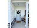 Covered entrance to this lovely home has natural stone accents, rocking chairs, and a wreath-adorned door at 5117 Farm Barn Ln, Raleigh, NC 27603