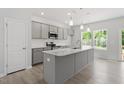 Modern kitchen featuring gray cabinets, stainless steel appliances, and a spacious center island at 55 Cordoba Dr, Franklinton, NC 27525