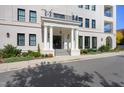 Elegant entrance to a condo building featuring stately columns, detailed trim, and manicured landscaping at 620 Wade Ave # 506, Raleigh, NC 27605