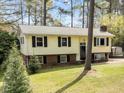 Inviting split-level home with a well-manicured lawn, dark shutters and mature trees adding character at 6216 Lewisand Cir, Raleigh, NC 27615