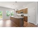 Modern kitchen featuring stainless steel appliances, an island with granite countertops, and hardwood floors at 65 Cordoba Dr, Franklinton, NC 27525