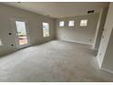 Open-concept living room area with door to the backyard and several windows allowing for lots of natural light at 76 Commons Cir, Clayton, NC 27520