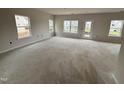Spacious living room featuring multiple windows that let in ample natural light and access to an outdoor patio at 76 Commons Cir, Clayton, NC 27520